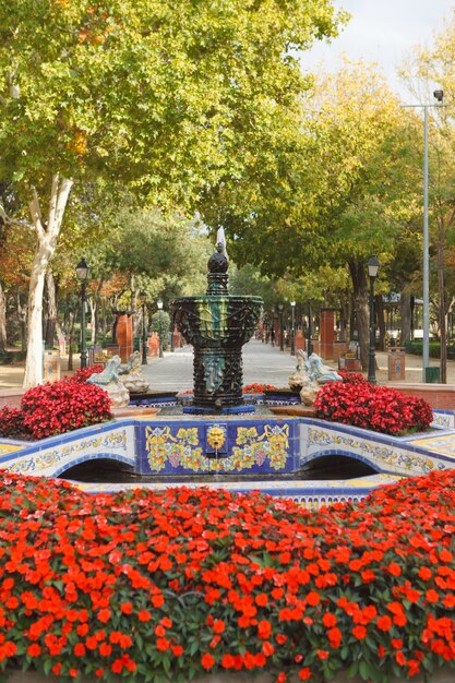 Photo beau parc avec beaucoup de fleurs rouges et une police