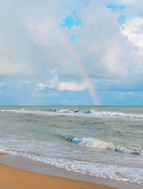 Beau paysage arc-en-ciel dans le ciel nuageux sur la mer vue depuis la plage