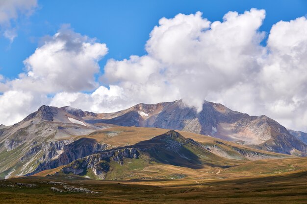 Beau paysage d'automne sans arbres de montagne avec des nuages et un ciel bleu