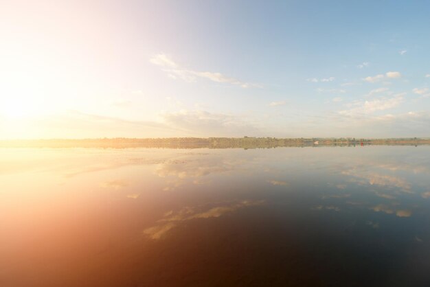 Beau paysage ciel bleu avec des nuages reflétés dans l'eau au lever ou au coucher du soleil