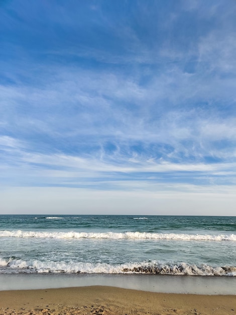 Beau paysage sur la côte de la plage et des vagues de la mer sur fond de ciel bleu