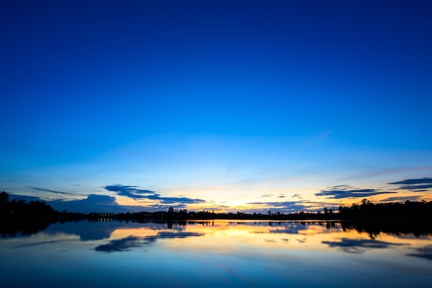 Beau paysage coucher de soleil avec un ciel bleu sur le lac