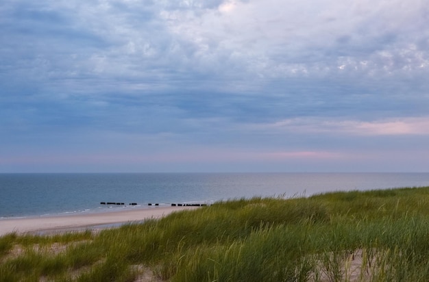 Beau paysage de coucher de soleil sur l'île de Sylt Allemagne avec la mer du Nord et les dunes d'herbe de marram