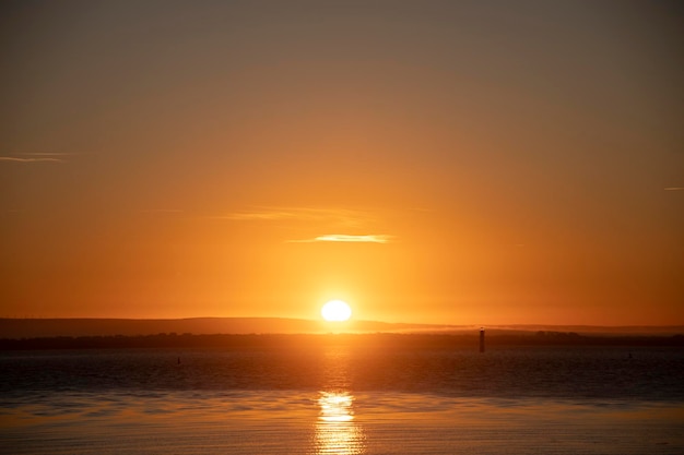 Beau paysage de coucher de soleil en mer avec un ciel clair et sans nuages heure d'or