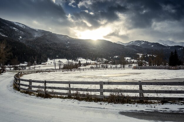 Beau paysage de ferme avec clôture en bois dans la ville autrichienne des hautes terres au coucher du soleil