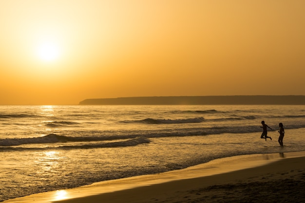 Photo beau paysage marin coucher de soleil avec silhouette de personnes