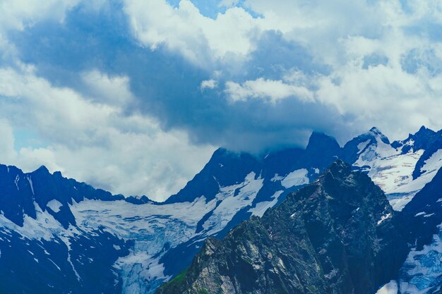 Beau paysage de montagne en été Puissantes montagnes enneigées par temps nuageux