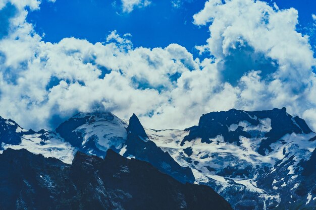 Beau paysage de montagne en été Puissantes montagnes enneigées par temps nuageux