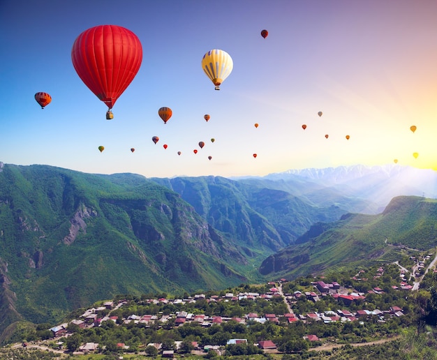 Beau paysage avec des montagnes verdoyantes et des montgolfières