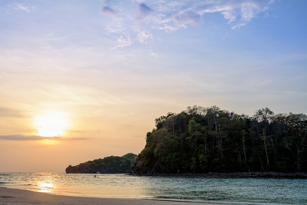 Beau paysage naturel coloré du soleil sur le ciel sur la plage de l'île de Tarutao pendant le coucher de soleil sur la mer d'Andaman, parc national de Tarutao, Satun, Thaïlande