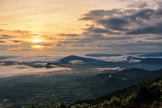 Beau paysage naturel le soleil est au-dessus du brouillard marin qui couvre les montagnes et le ciel lumineux pendant le lever du soleil en hiver au point de vue du parc national de Phu Ruea, province de Loei, Thaïlande.