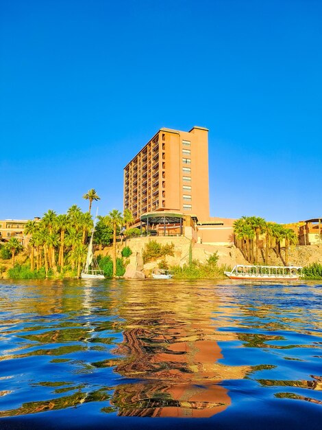 Beau paysage panoramique avec des bateaux felucca sur le Nil à Aswan au coucher du soleil