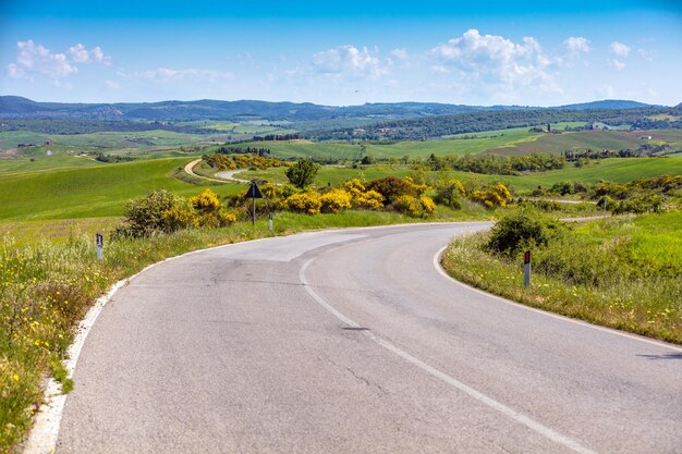 Beau paysage printemps nature Route provinciale sinueuse parmi les champs ensoleillés en Toscane Italie