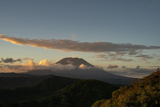 Beau paysage de vallée de montagne et volcan majestueux entouré de nuages denses photo stock