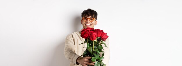 Beau petit ami vous donnant un bouquet de roses faire un cadeau surprise lors d'un rendez-vous romantique à la saint valentin