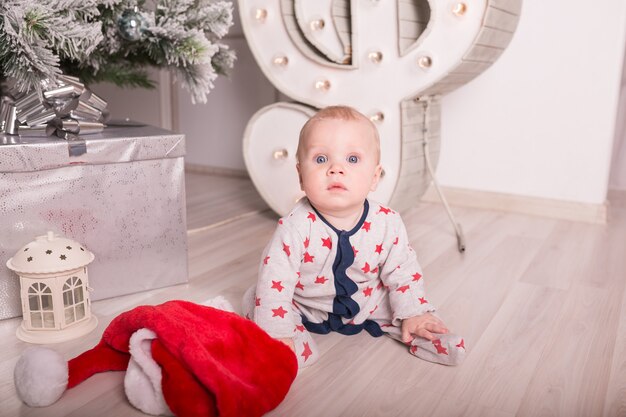 Beau petit bébé fête Noël. Les vacances du nouvel an. Bébé en costume de Noël avec cadeau