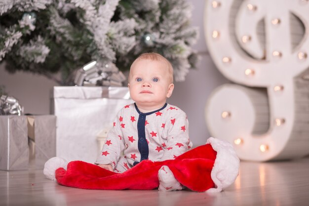 Beau petit bébé fête Noël. Les vacances du nouvel an. Bébé en costume de Noël avec cadeau