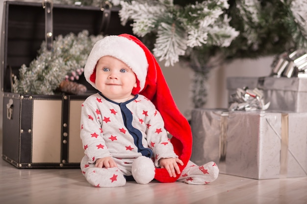 Beau petit bébé fête Noël. Les vacances du nouvel an. Bébé en costume de Noël avec cadeau