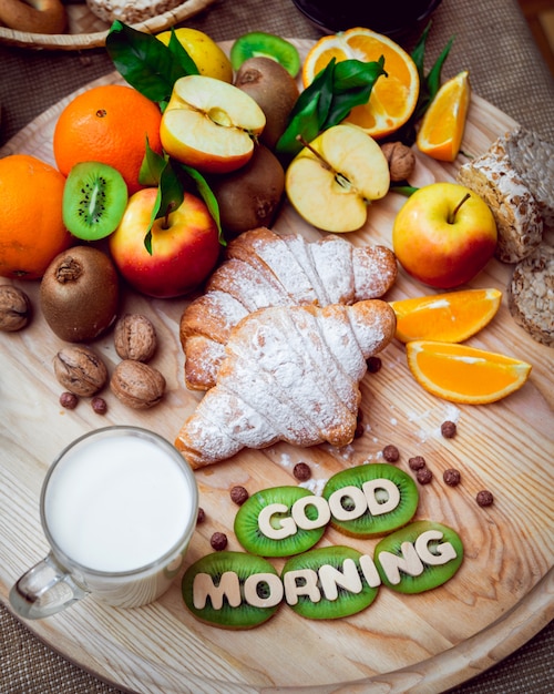 Photo beau petit déjeuner. fruits au lait, pain et croissant.