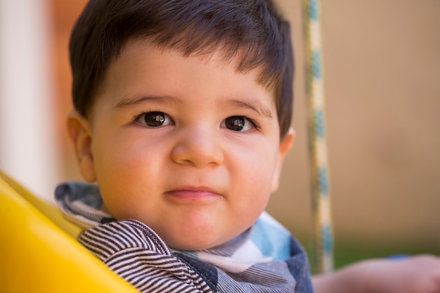 Beau Petit Garçon Brésilien Regardant La Caméra. Bébé Sur La Balançoire. Bébé Heureux.