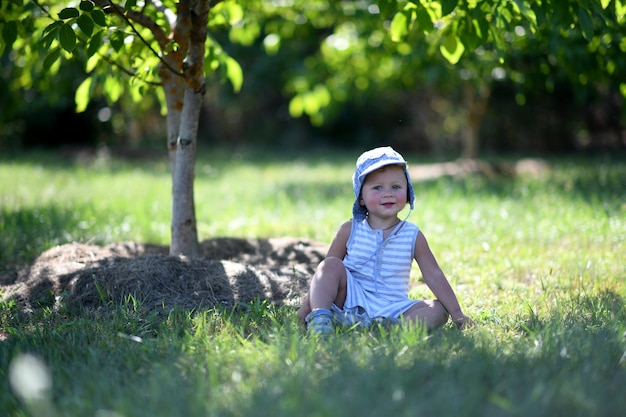 Beau petit garçon dans un jardin d'enfant posant photographe pour photo couleur Cadre composé de bébé garçon