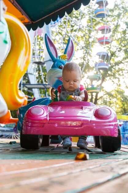 Beau petit garçon sur la machine de manège