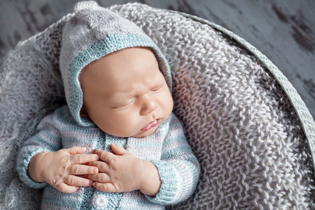 Beau petit garçon nouveau-né de 20 jours dort dans un panier. Portrait de joli garçon nouveau-né