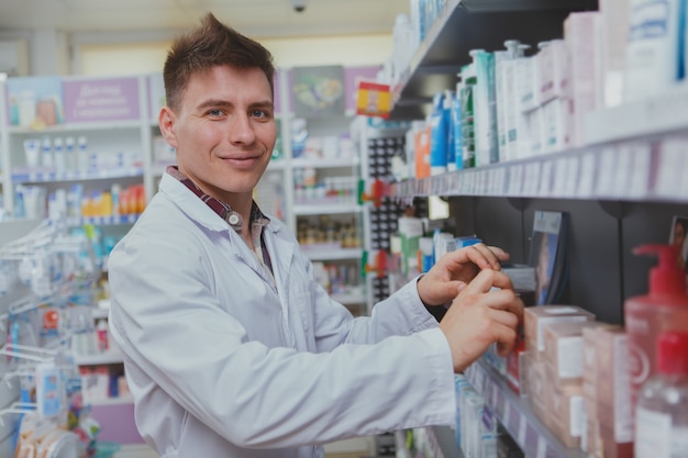 Beau pharmacien homme travaillant dans sa pharmacie