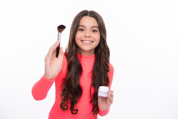 Beau portrait d'adolescente enfant artiste appliquer de la poudre avec un pinceau de maquillage Produits de maquillage Beauté et cosmétiques pour adolescents Bonne fille face à des émotions positives et souriantes