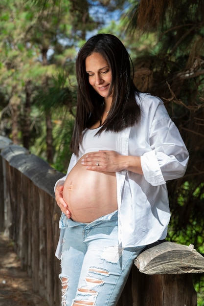 Beau portrait de femme enceinte dans un parc.