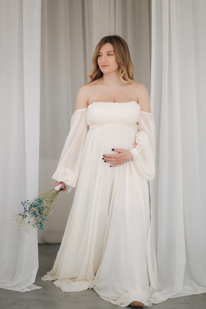 Beau portrait de femme enceinte en robe blanche concept de grossesse parfaite future mère est