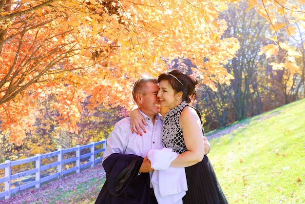 Beau portrait d'heureux jeune couple amoureux lors d'une promenade dans la forêt d'automne