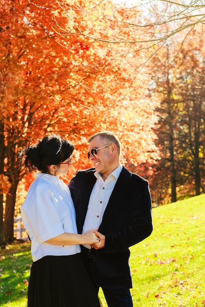 Beau portrait d'heureux jeune couple amoureux lors d'une promenade dans la forêt d'automne