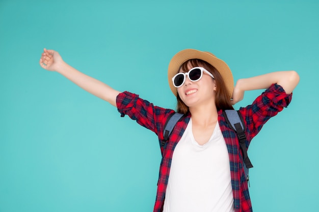 Beau portrait jeune femme asiatique porter des lunettes de soleil et un chapeau sourire excité et confiant profiter des vacances d'été isolé fond bleu.