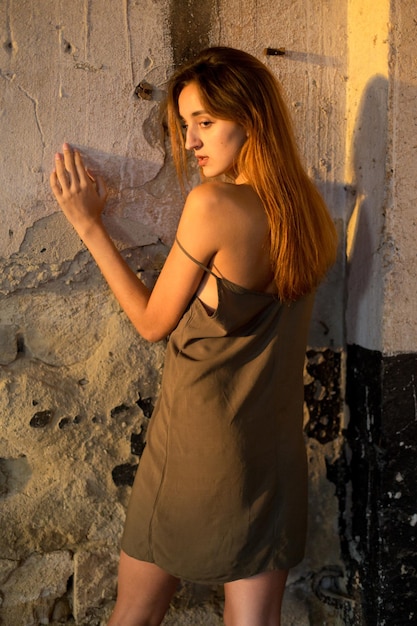 Beau portrait d'une jeune fille sur un fond en bois Jeune fille en robe légère sur les bretelles