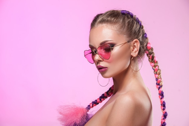 Beau portrait d'une jeune fille. Maquillage et coiffure professionnels en tresses colorées