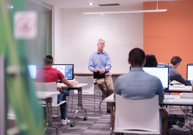 beau professeur mature et étudiants en classe de laboratoire informatique