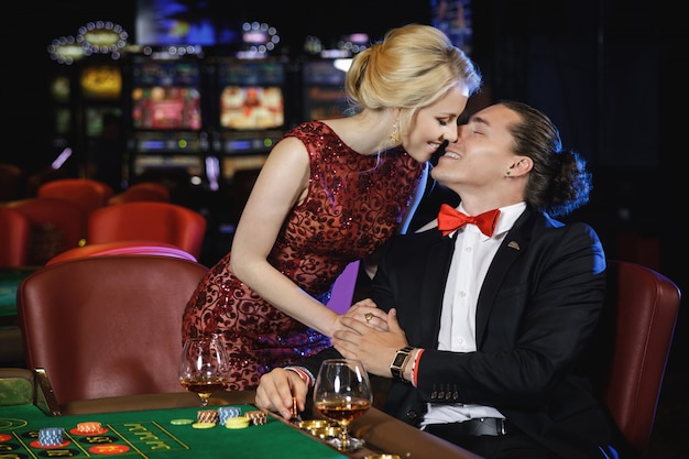 Beau et riche couple jouant à la roulette au casino