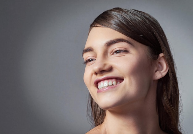 Beau rire Prise de vue en studio d'une belle jeune femme posant sur un fond gris