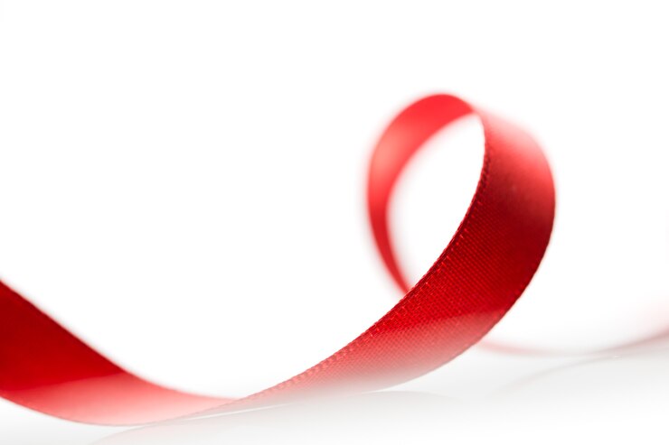 Photo beau ruban rouge en tissu sur une surface blanche