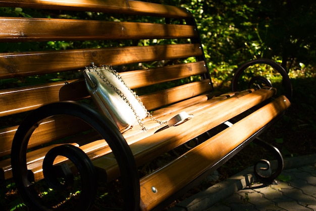 Beau sac pour femme allongé sur un banc en bois