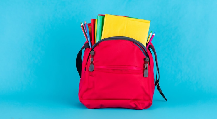 Photo beau sac scolaire rouge ouvert avec des livres à l'intérieur