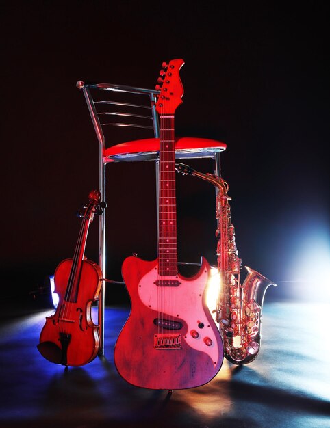 Beau saxophone doré et guitare près d'un tabouret de bar sur une scène