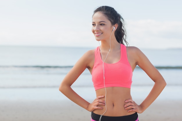 Beau sourire en bonne santé avec des écouteurs sur la plage