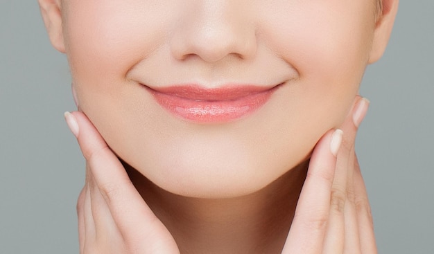 Beau sourire féminin avec macro de brillant à lèvres naturel