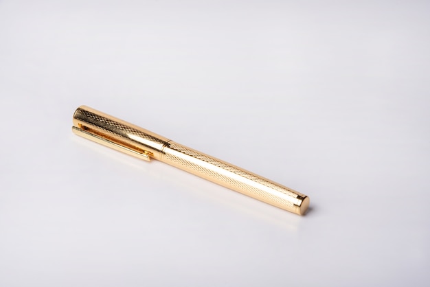 Beau stylo plume doré sur surface blanche