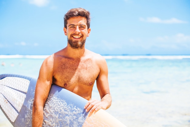 Beau surfeur sur une plage