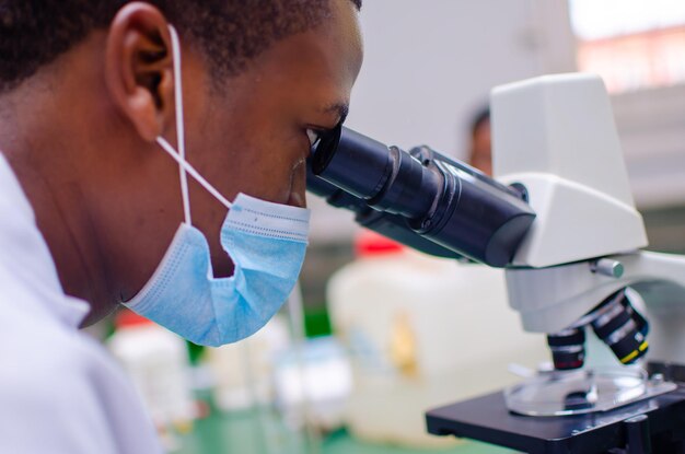 Beau technicien de laboratoire ou scientifiques travaillant en laboratoire regardant à travers des microscopes