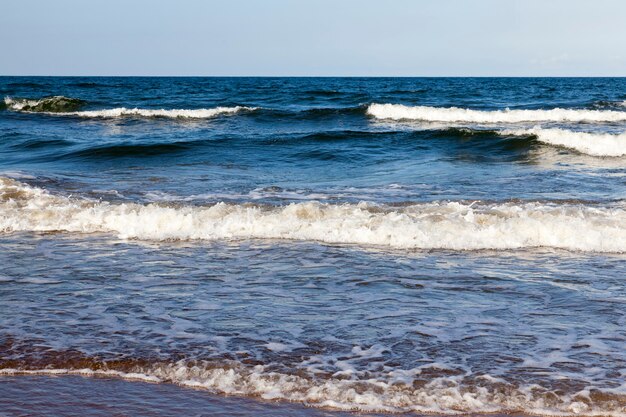 Beau temps ensoleillé sur la côte de la mer Baltique, temps d'été froid sur la côte de la mer Baltique, paysage marin sur la mer par une journée ensoleillée avec un ciel bleu et beaucoup de vagues sur l'eau