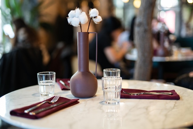 Beau vase avec des fleurs de coton sur la table